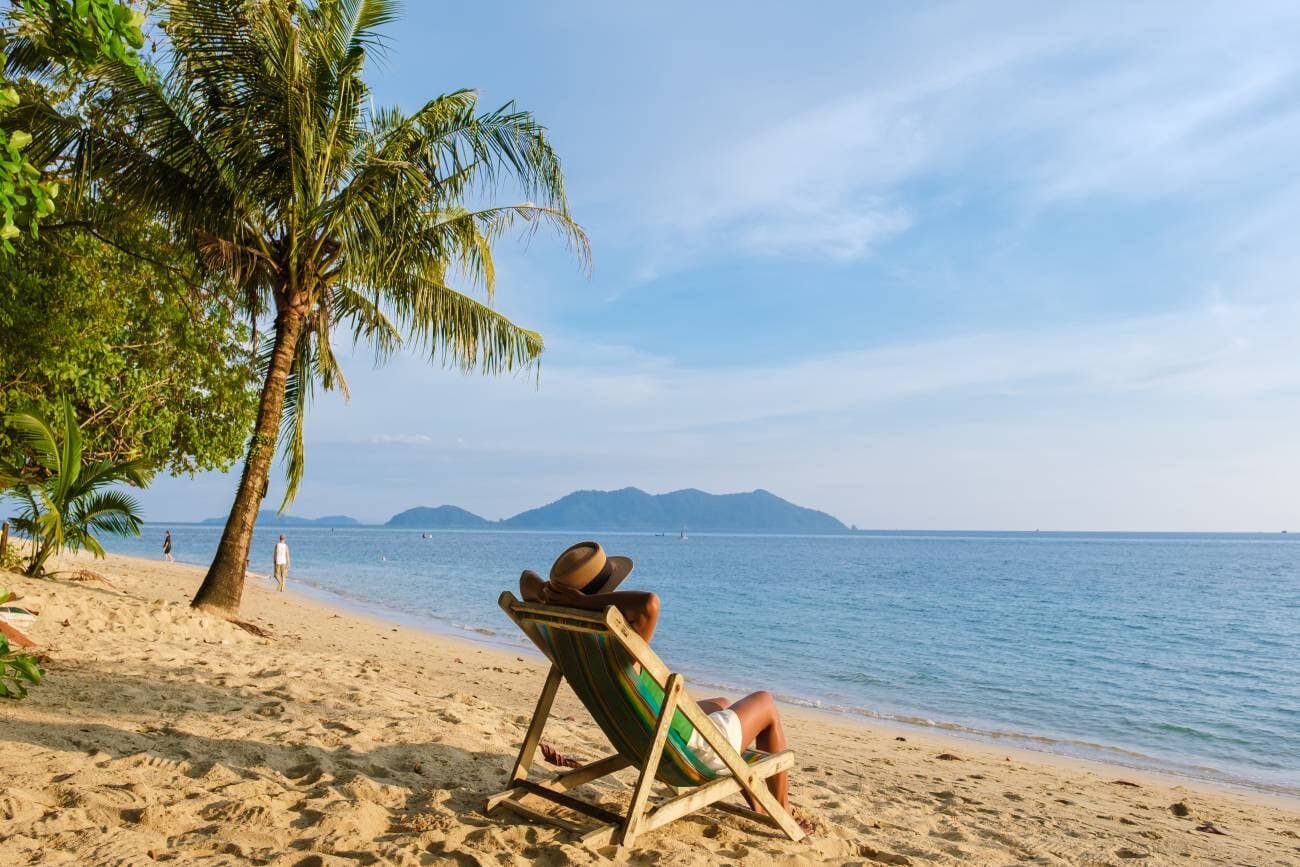 Bangkok to Koh Chang: Your Ultimate Guide to Planning a Smooth Journey 2 Asian Thai woman enjoying the sunset while relaxing on a beach chair at Klong Kloi Beach, Koh Chang, Thailand
