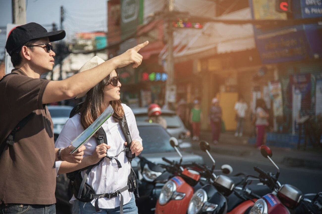 Why Suvarnabhumi Golf and Country Club Should Be Your Next Golfing Destination in Thailand 1 Asian tourist couple holding a city map while crossing the road.