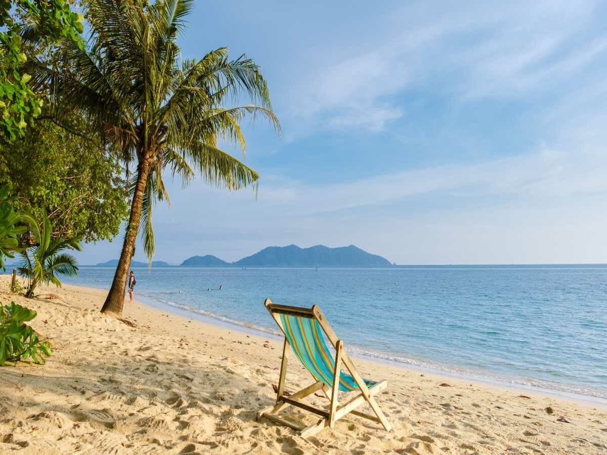 Beach chairs are neatly arranged on Klong Kloi Beach, offering a relaxing tropical escape in Koh Chang, Thailand