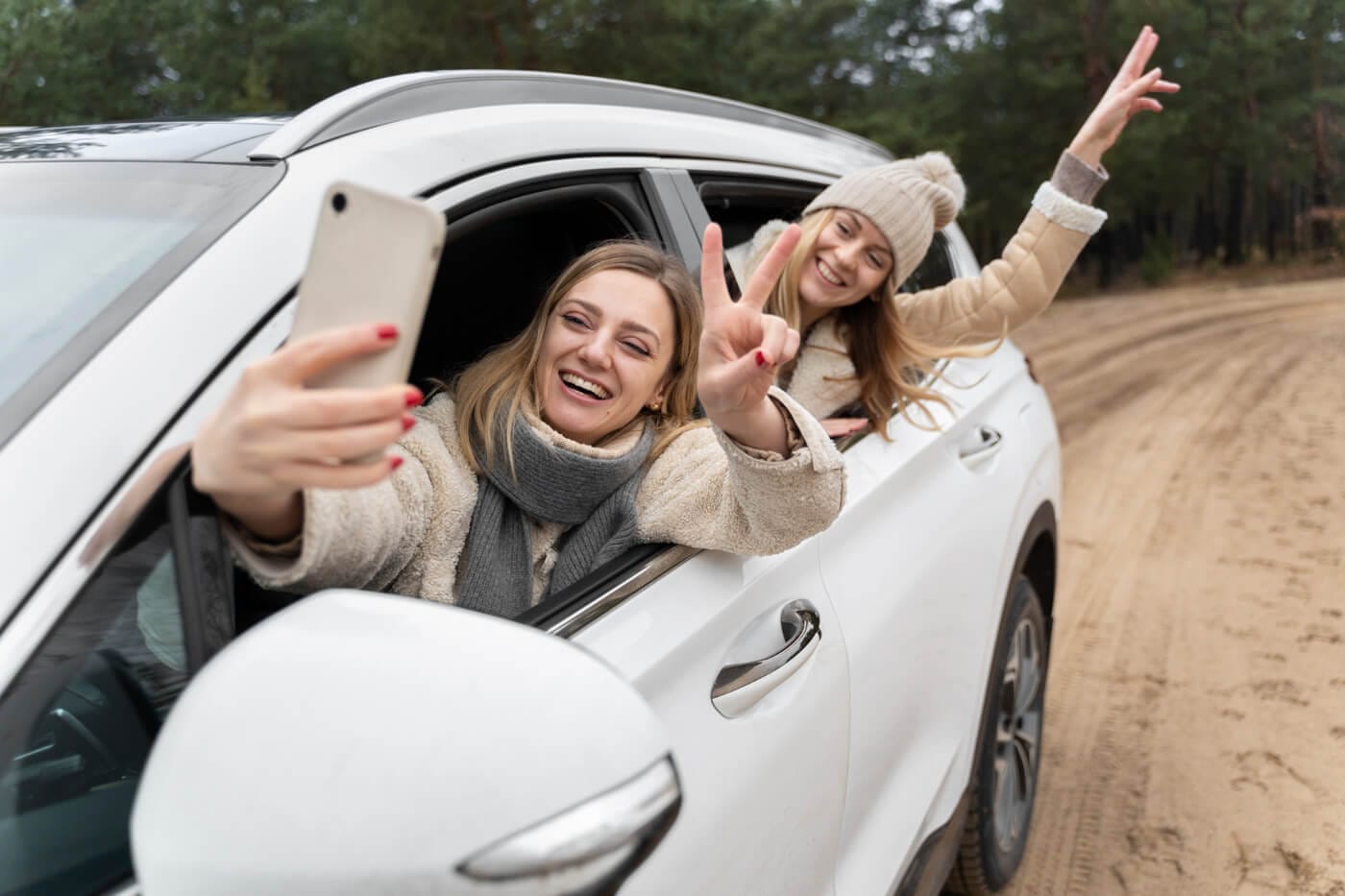Female friends snapping a selfie outside a taxi car's window