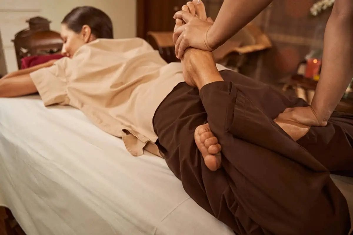 Ultimate Guide to Experiencing the Best Thai Massage in Bangkok: Prices, Locations & Insider Tips 3 Practitioner executing a lower leg stretch on a client during a traditional Thai massage