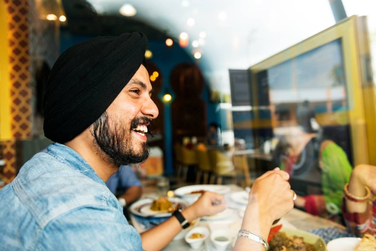 Top 10 Must-Try Veg Restaurants in Bangkok: Unleashing Flavors That Satisfy 1 Smiling Indian man representing a restaurant concept.