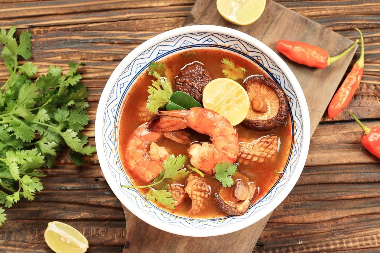 Street Food Bangkok: 5 Must-Try Dishes You Can't Miss 2 Traditional Thai cuisine, Tom Yum Goong spicy soup, elegantly presented on a wooden background
