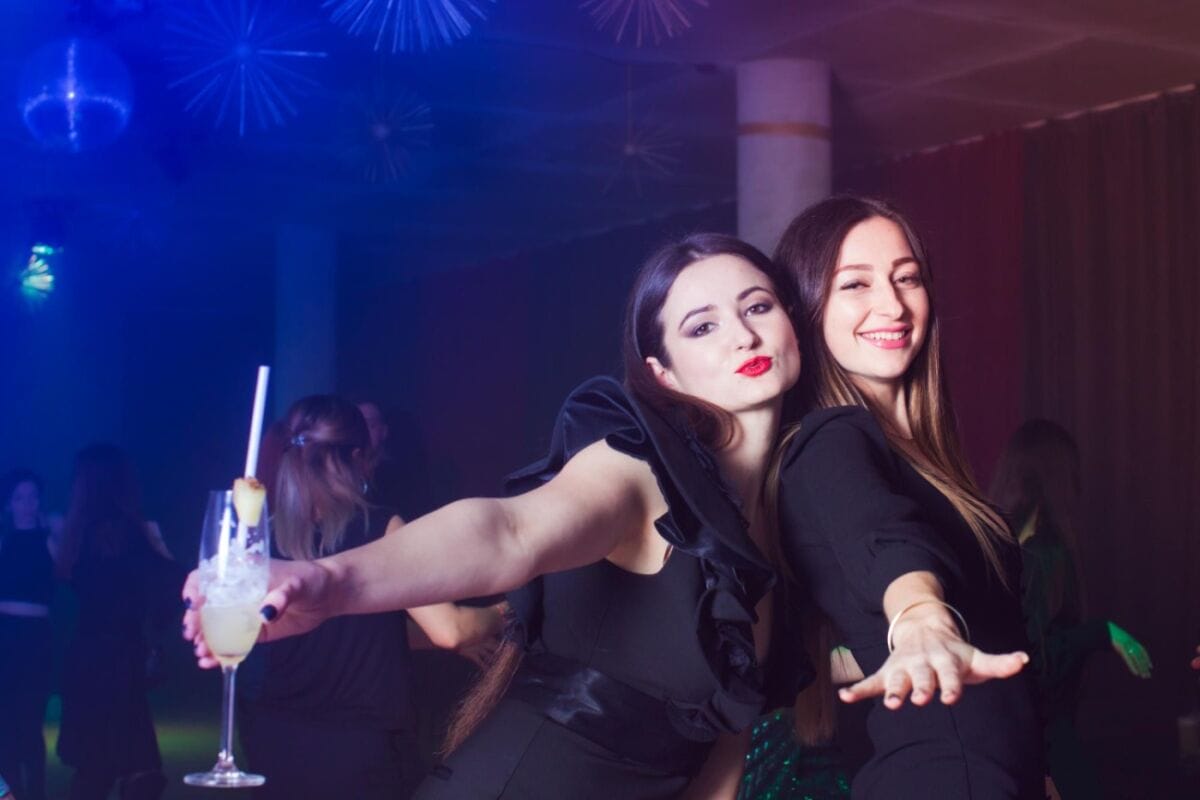 From Dancers to Drinks: A Guide to A Go Go Pattaya 2 Two beautiful women in elegant black dresses enjoying the night, having fun while sipping cocktails