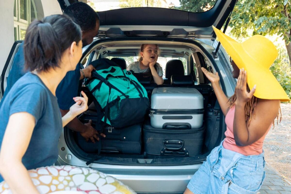 Young girl and diverse group packing bags into a vehicle for a vacation. They're preparing luggage with family and friends, ready for a holiday road trip adventure.