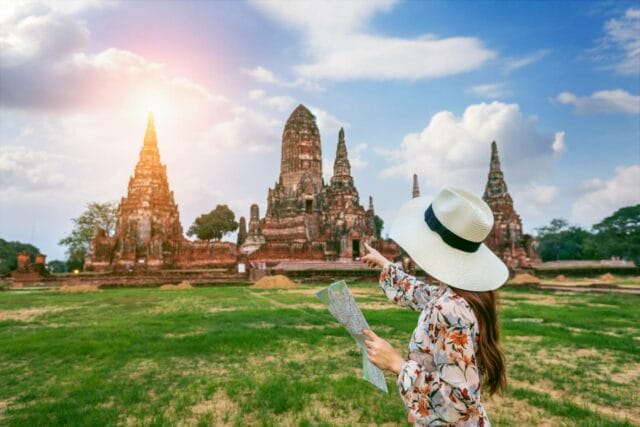 Young girl exploring Wat Chaiwatthanaram, a Buddhist temple in Ayutthaya Historical Park, Thailand, as part of a sightseeing adventure